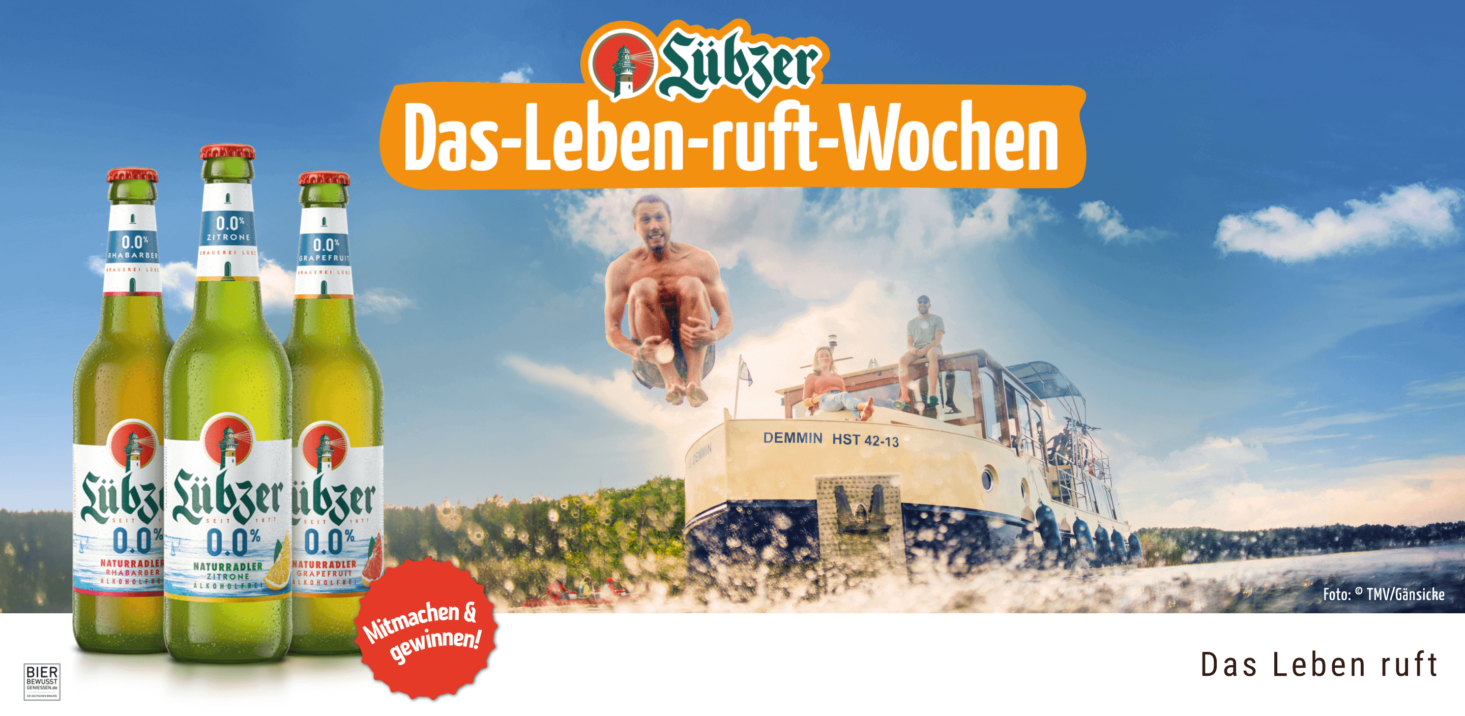 Drei Flaschen Lübzer Naturradler Akoholfrei. Im Hintergrund ist ein Hausboot mit Menschen abgebildet.